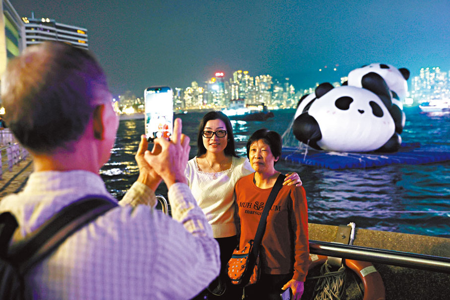 ●尖沙咀海面上的兩隻巨型充氣大熊貓裝置成為打卡熱點。 香港文匯報記者郭木又 攝