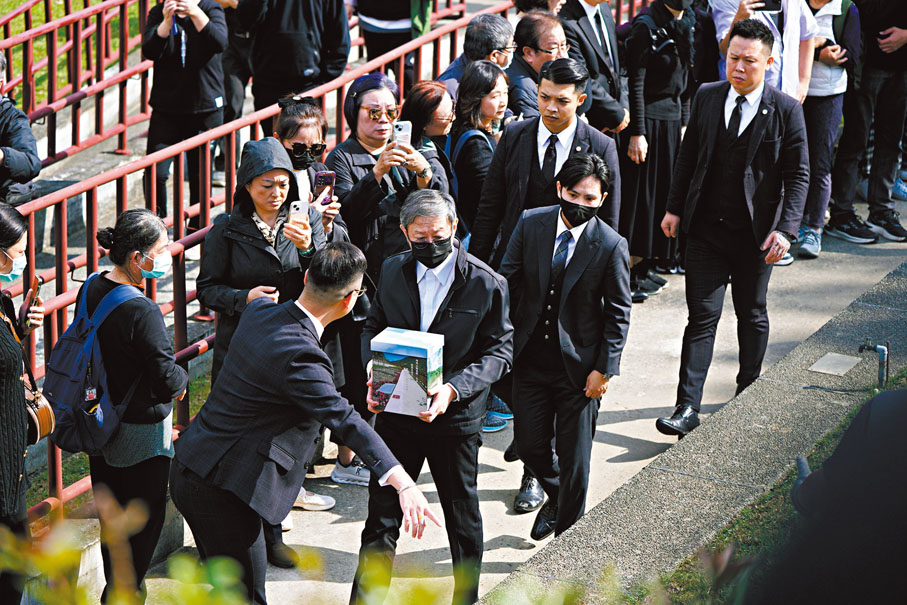 ●瓊瑤的家屬抱着骨灰抵達現場，禮儀公司人員上前引導。台媒圖片