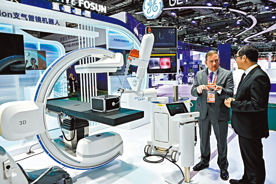 ●中央經濟工作會議提出，明年要有序擴大自主開放和單邊開放，穩步擴大制度型開放。圖為外賓早前在第七屆進博會直觀復星展台了解一款支氣管鏡機器人。 資料圖片