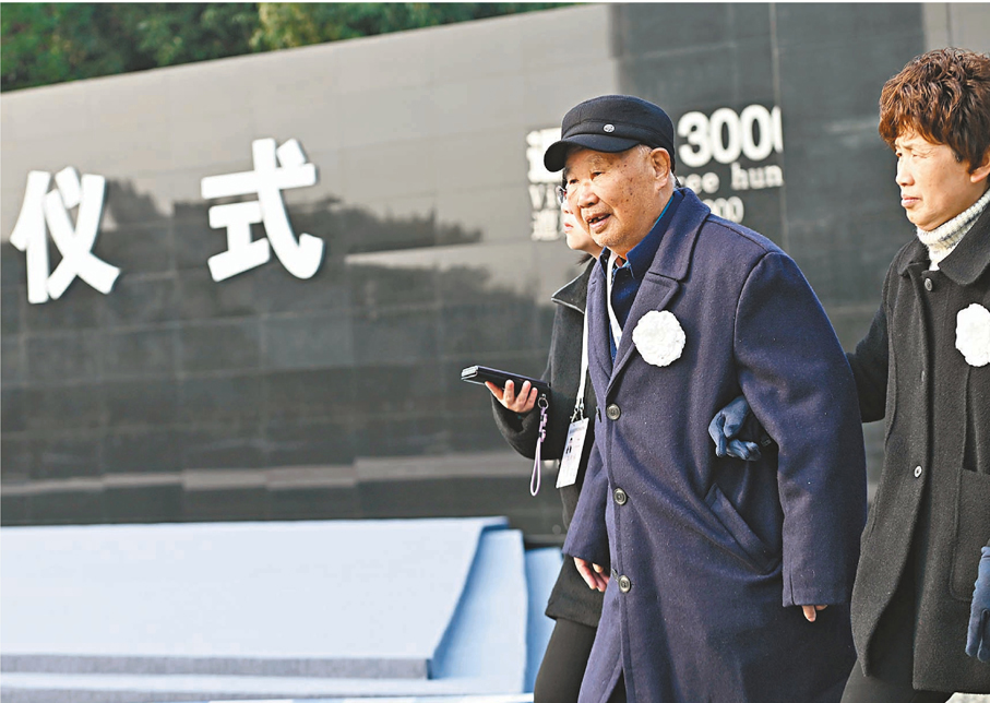 ●12月13日，南京大屠殺倖存者劉民生（前左）到達南京大屠殺死難者國家公祭儀式現場。新華社