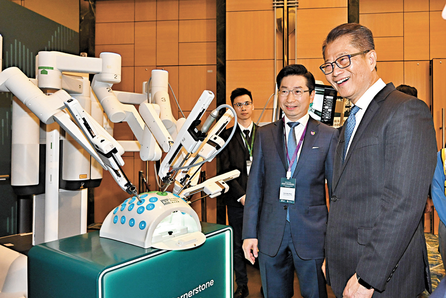 ●圖為陳茂波（右）在香港中文大學醫學院院長趙偉仁教授（中）陪同下參觀展覽。 政府新聞處圖片