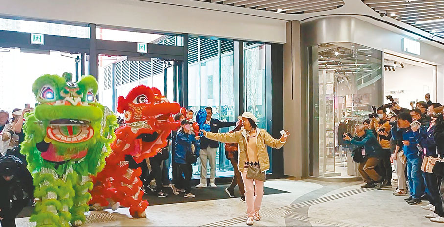 ●啟德零售館昨日中午正式試業，第一位入館的市民興奮與醒獅共舞。香港文匯報記者張茗  攝
