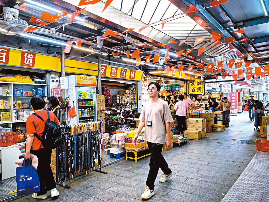 ●俞強在中英街走訪商舖。香港文匯報記者郭若溪 攝