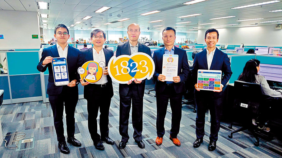 ●林國偉（中）等在訪問中介紹使用創新科技提升1823服務。香港文匯報記者劉啟業  攝