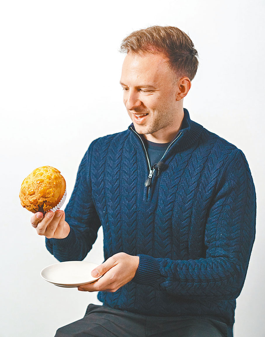 ●卓林普首次品嘗香港特色食品菠蘿包和蛋撻，他對菠蘿包讚不絕口。  香港人才服務辦公室供圖