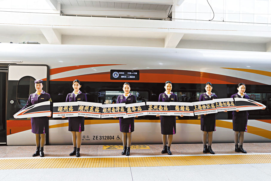 ●12月26日9時45分，湖州東-上海虹橋的G9508次高鐵列車從湖州東站開出，標誌着滬蘇湖高鐵正式開通運營。圖為乘務員在G9508次高鐵列車車廂外合影。  中新社