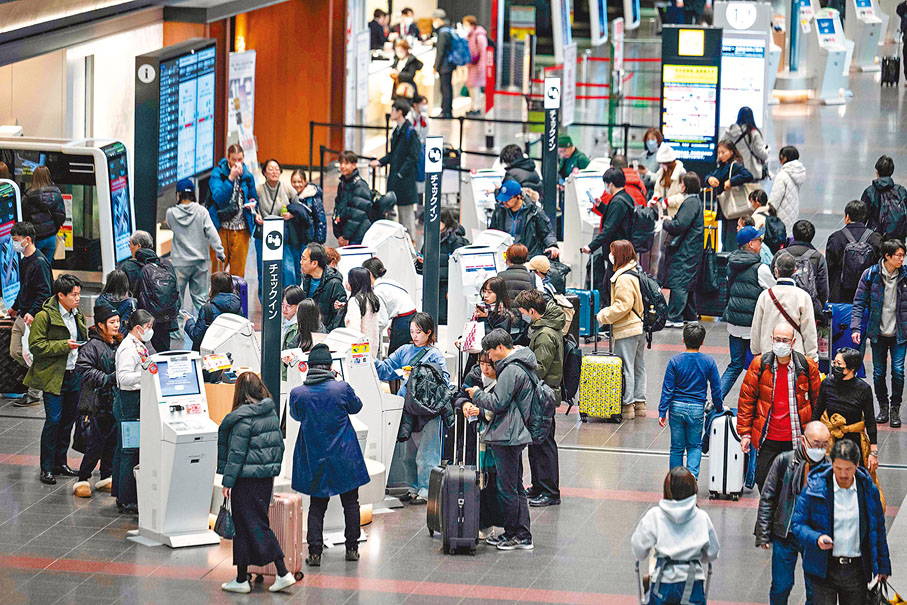 ●羽田機場有大批日航旅客等候辦理登機手續。 法新社