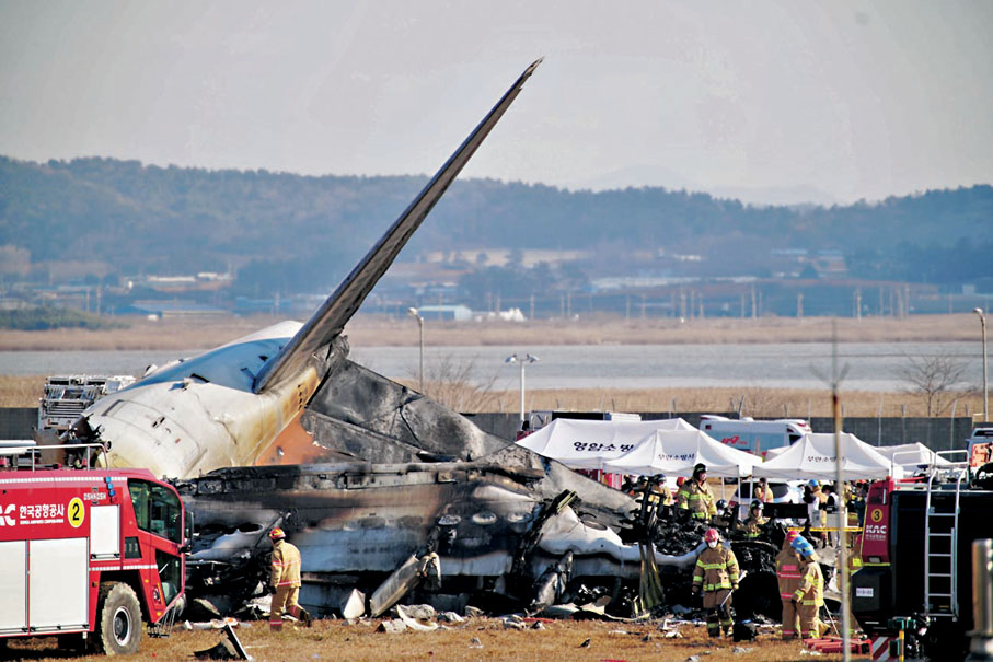 ●韓國濟州航空一架客機失事，179人遇難。圖為消防員在失事飛機現場滅火和救援，飛機變成一堆廢鐵。 中新社發  韓國紐斯頻通訊社供圖