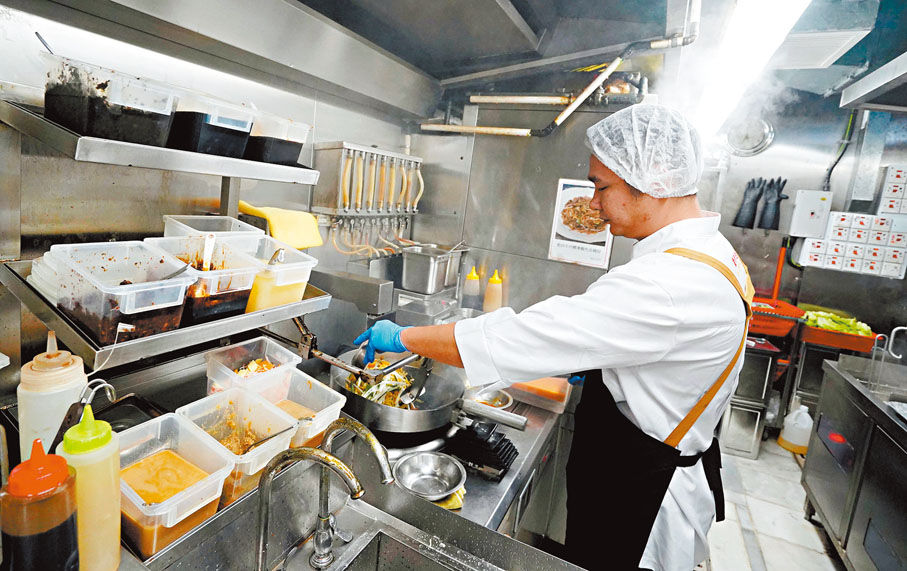 ●孫玉菡表示，現正檢討輸入勞工計劃，但暫時無意將輸入勞工計劃擴展至其他行業。圖為外勞廚工用心為客人炒菜。 資料圖片