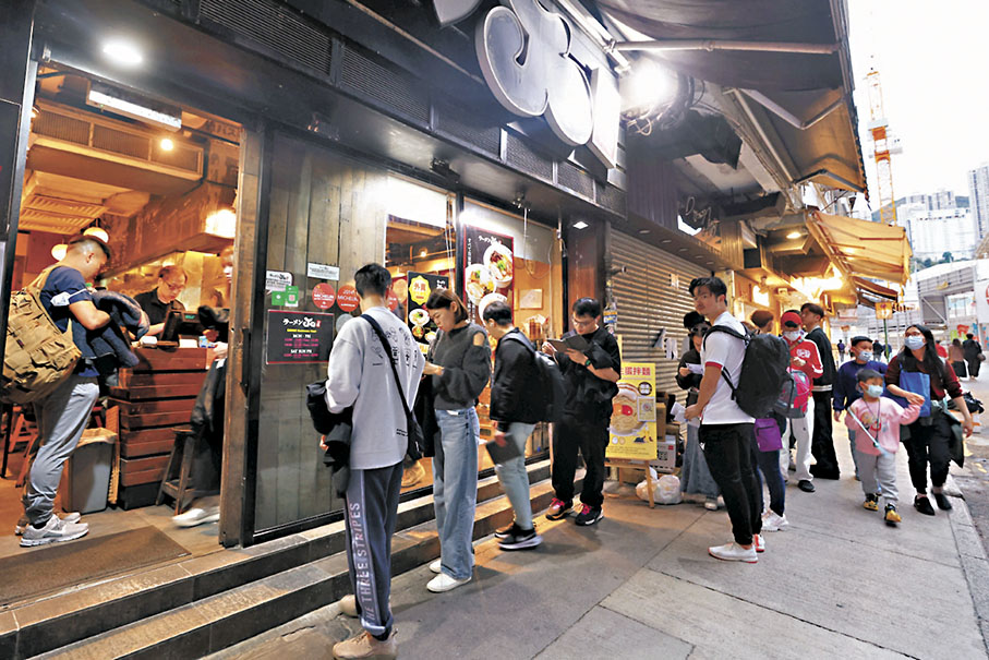●賀歲盃效應帶動下,大球場周邊食肆排起人龍。 香港文匯報 記者北山彥 攝