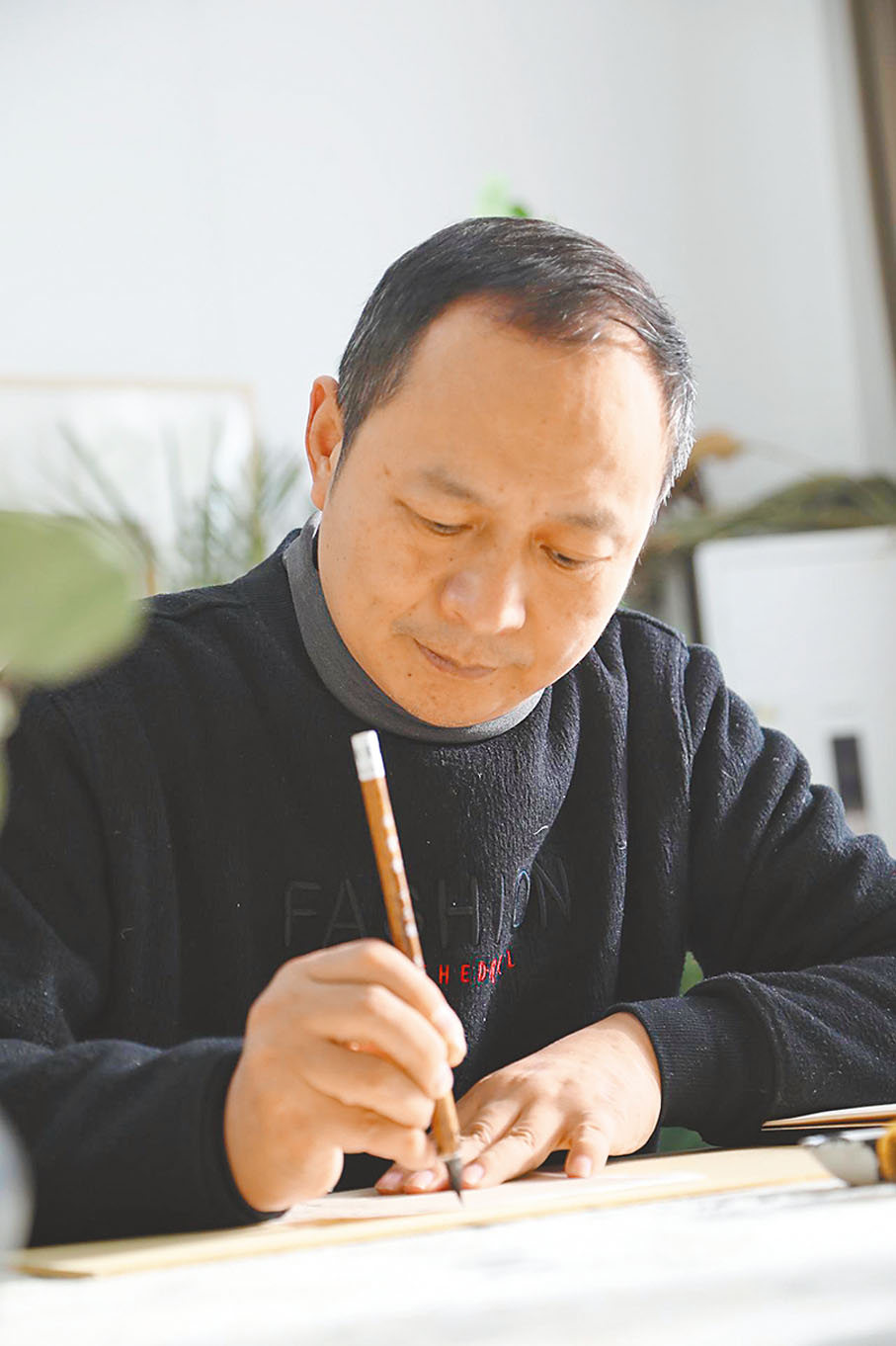 ●李明潛心進行書法創作。