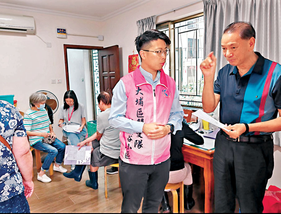 ●張育文(右二)在區內介紹關愛隊服務,推動鄰里互助。 作者供圖