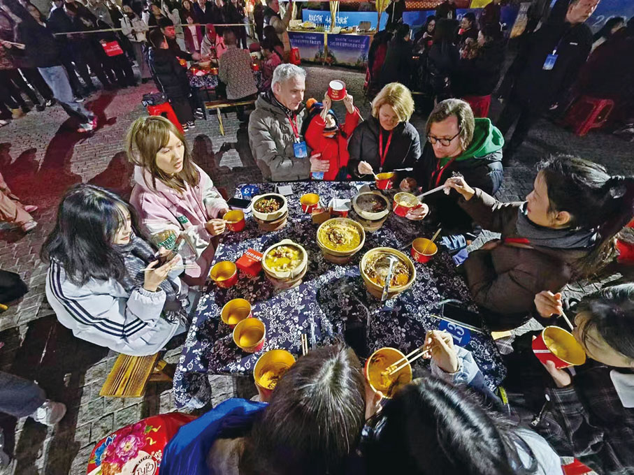 ●國外遊客在張家界七十二奇樓品嚐當地美食。