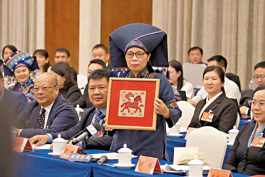 ●廣西人大代表在現場展示非遺產品壯繡。香港文匯報記者帥誠 攝