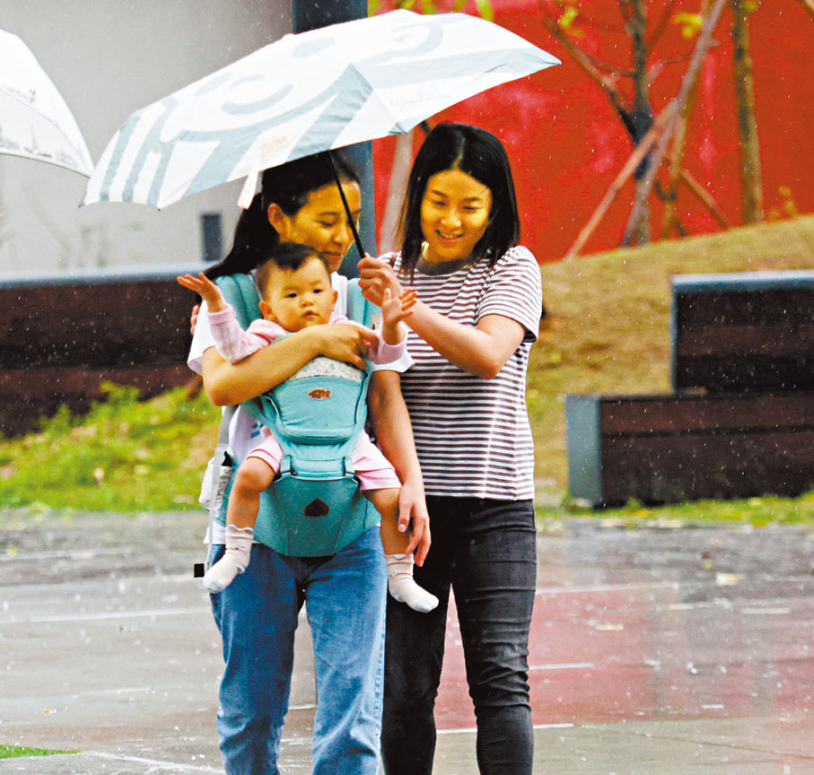 ●有小朋友在雨中「自得其樂」。香港文匯報記者曾興偉  攝