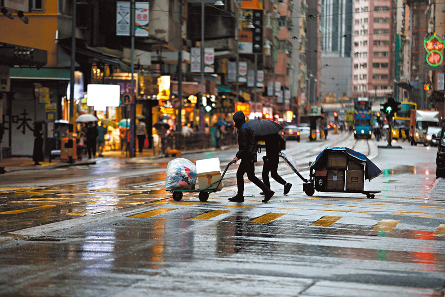 ● 有工人暴雨中繼續搬貨。 香港文匯報記者萬霜靈  攝