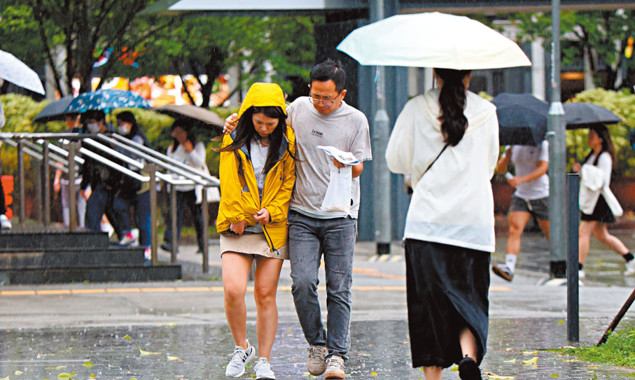 ● 忽然起風雨，途人流露吃不消的表情。香港文匯報記者北山彥  攝
