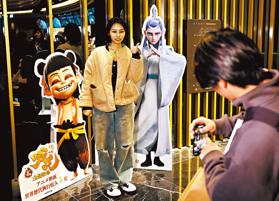 ●觀眾在《哪吒2》日本首映禮後與電影宣傳板合影。 新華社
