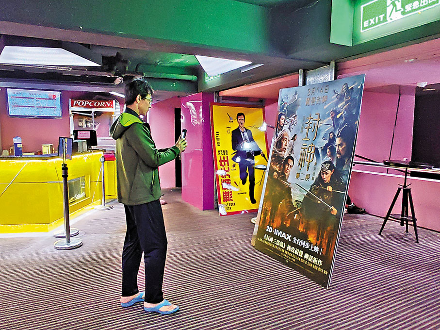 ●台北新民生戲院展示的《封神2》海報吸引影迷拍照。  中新社