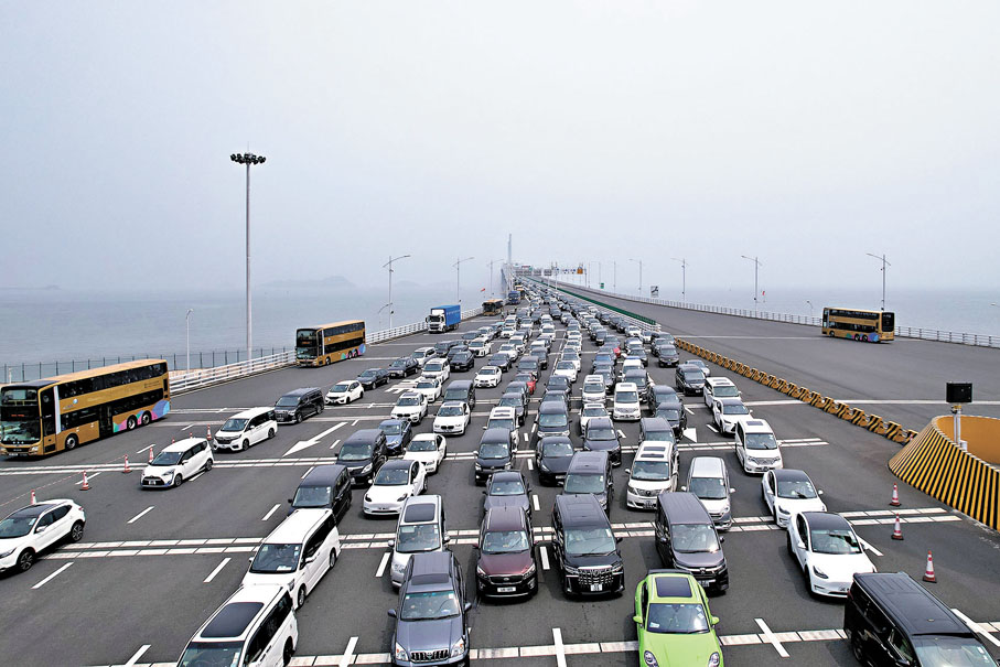 ●持有兩地車牌的車主希望兩地能實施「一車多關」,可以自由選擇不同口岸出入。圖為假期港珠澳大橋出現長長的車龍。 資料圖片