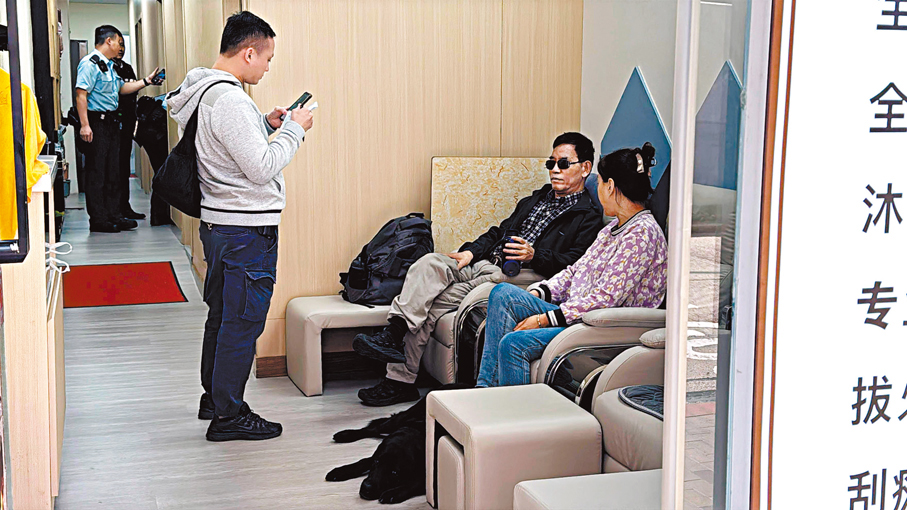 ●推拿店姓朱男負責人(左)返回店舖助查。