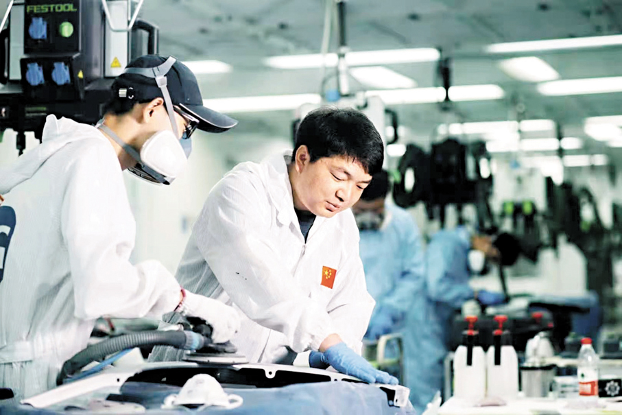 ●全國人大代表、杭州技師學院整形塗裝與設計學院副院長楊金龍(右)指導學生進行噴漆打磨。 香港文匯報北京傳真