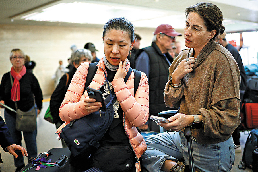 ●在意大利羅馬等待飛往希思羅機場的旅客,透過手機了解航班情況。 路透社