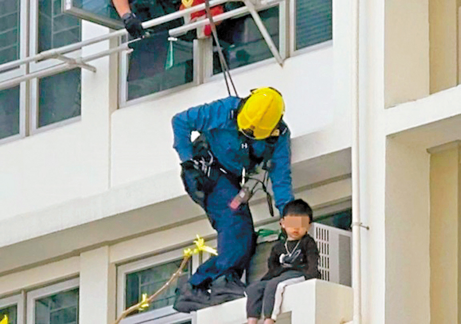 ● 消防「飛將軍」爬出窗外,為男童繫上安全繩後,將男童抱起遞給接應同袍和警員。 網上截圖