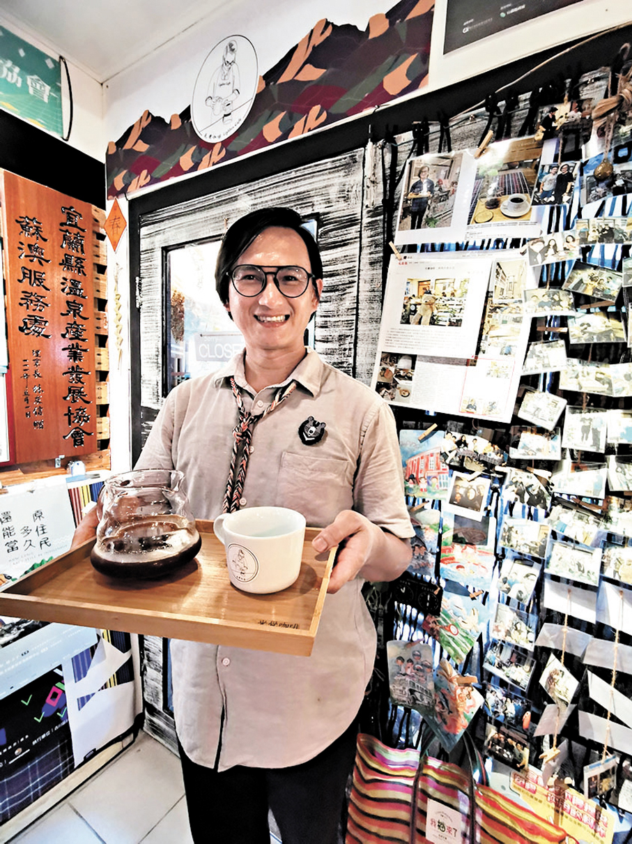 ●光覺咖啡老闆小光站在貼上香港文匯報記者數年前採訪過他的報道的剪報前拍照。