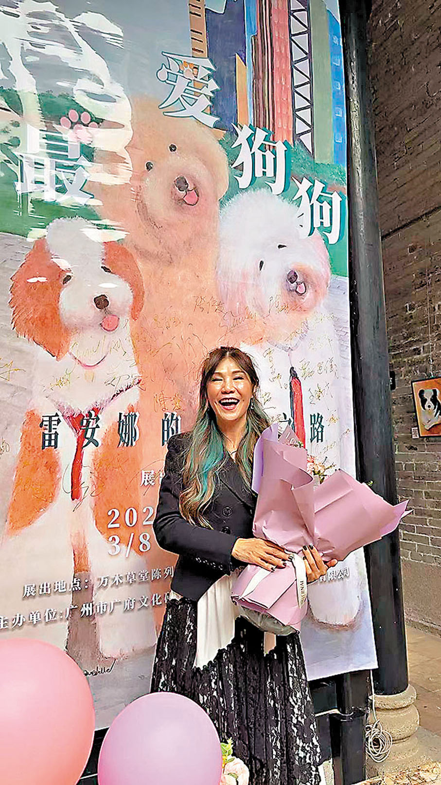 ●雷安娜站在她的畫展開幕禮的巨型作品前開心拍照。作者供圖