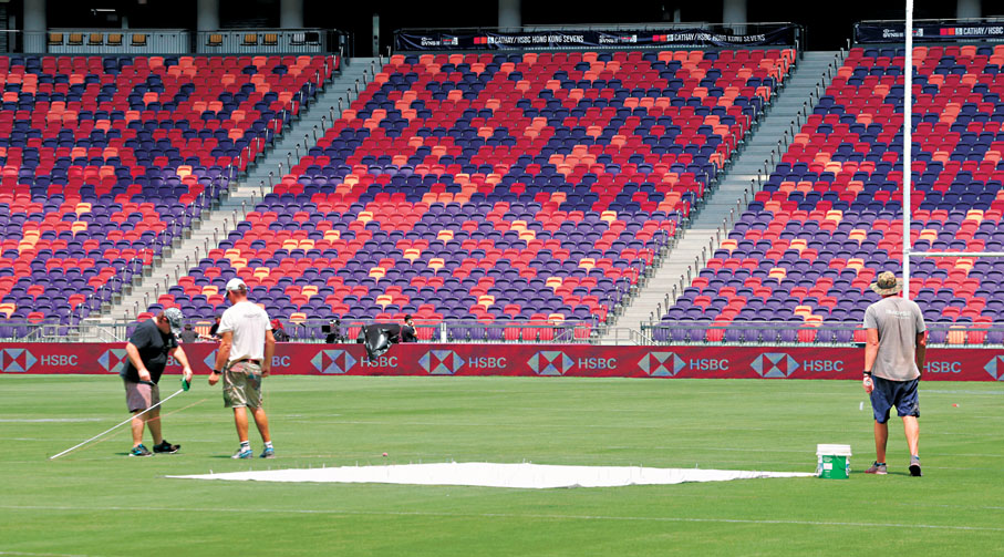 ●工作人員視察啟德主場館的草地。香港文匯報記者郭木又  攝