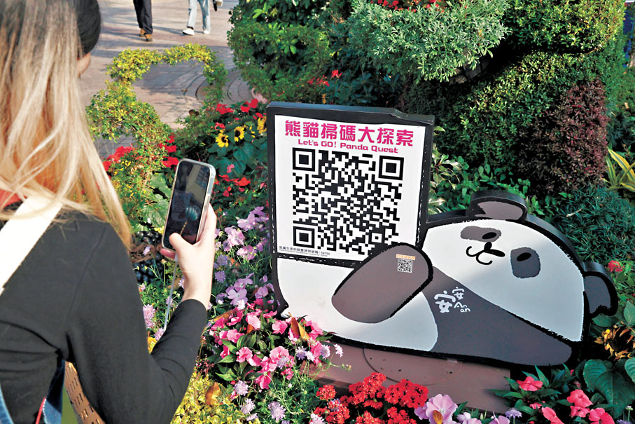 ●入場者尋找園內「熊貓掃碼大探索」二維碼，用手機掃描完成簡單任務。香港文匯報記者郭木又  攝