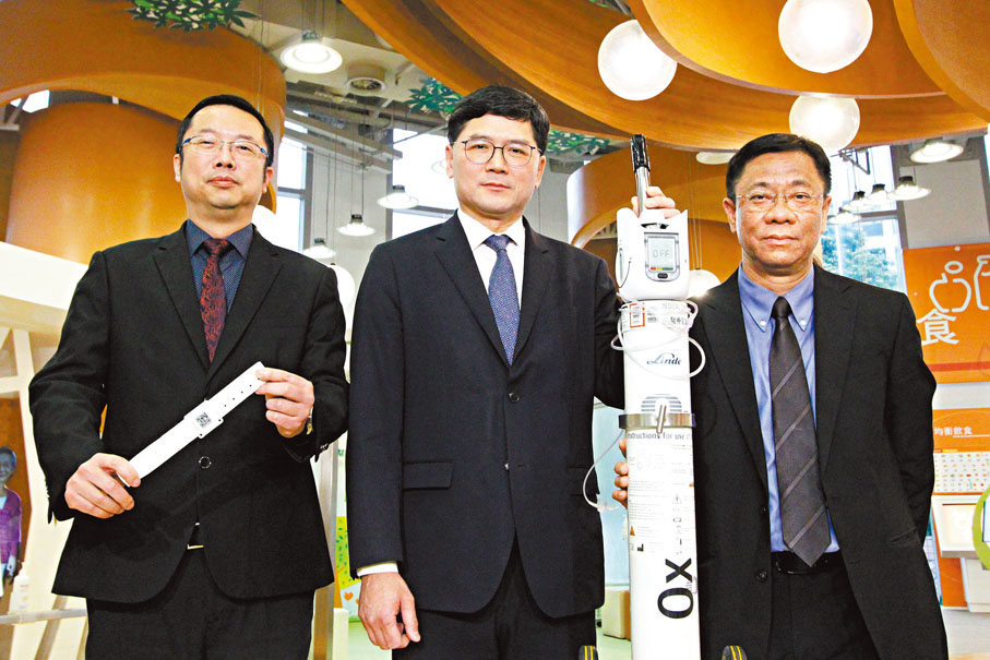 ●左起:黃立己(手持藍牙裝置手帶)、醫管局行政總裁高拔陞(手持智能氧氣樽)、張偉文。 香港文匯報記者黃艾力 攝