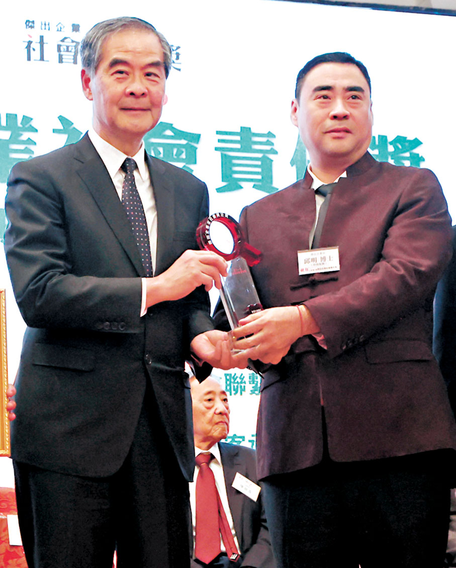 ●梁振英(左)向坤鼎集團董事長邱明頒獎。香港文匯報記者黃艾力 攝
