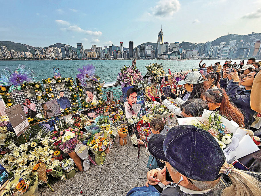 ●大批「哥」迷聚集在香港星光大道的張國榮手印前悼念。 中通社
