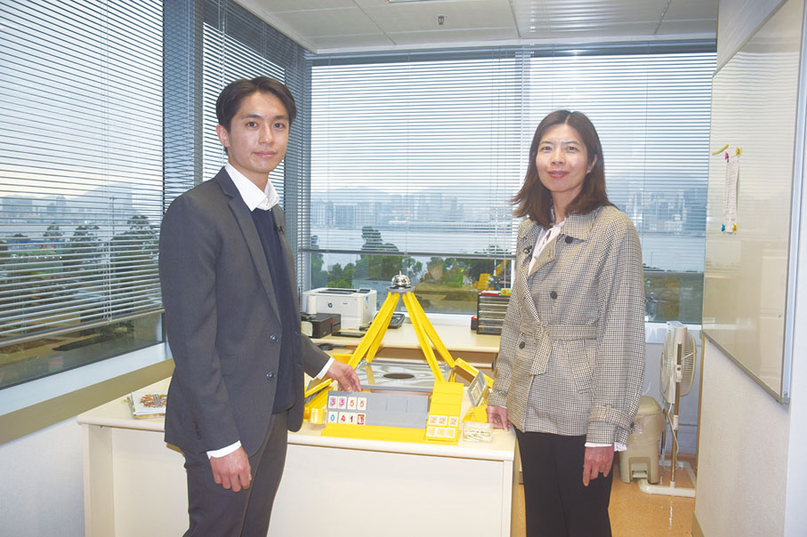 ●社署臨床心理學家鍾瑋軒(左)和曾佩珊介紹社署專為受發展障礙影響人士而設計的「叮叮樂」桌上群體遊戲,藉以提升其社交互動及認知能力。