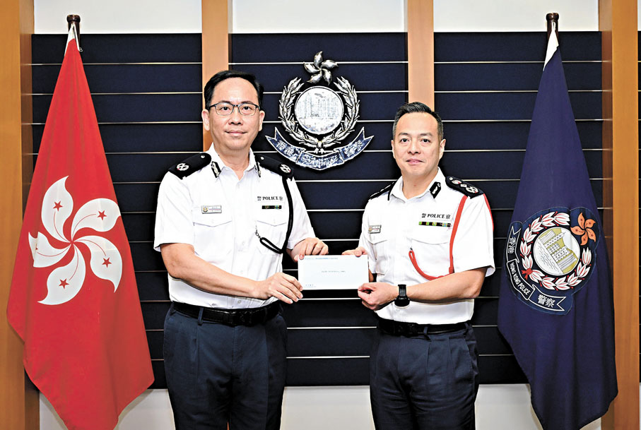 ●警務處處長周一鳴（右）頒授委任狀予新委任香港輔助警察隊總監梁世光（左）。