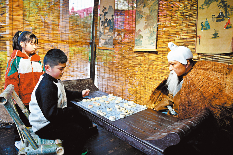 ●老人裝扮成「姜太公」與小孩下棋。
