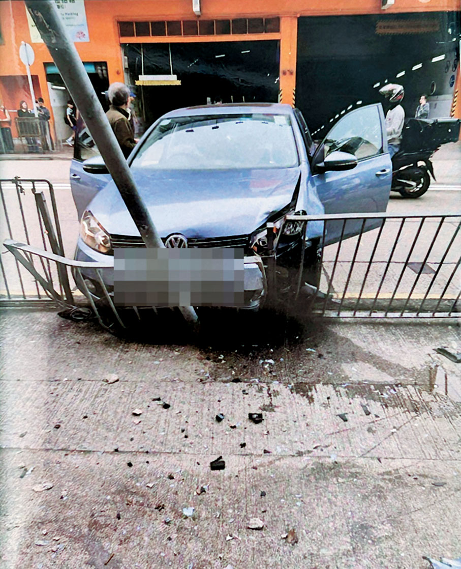●失控私家車由停車場衝出,撞向對面馬路的鐵欄及路牌才停下,車頭毀爛。
