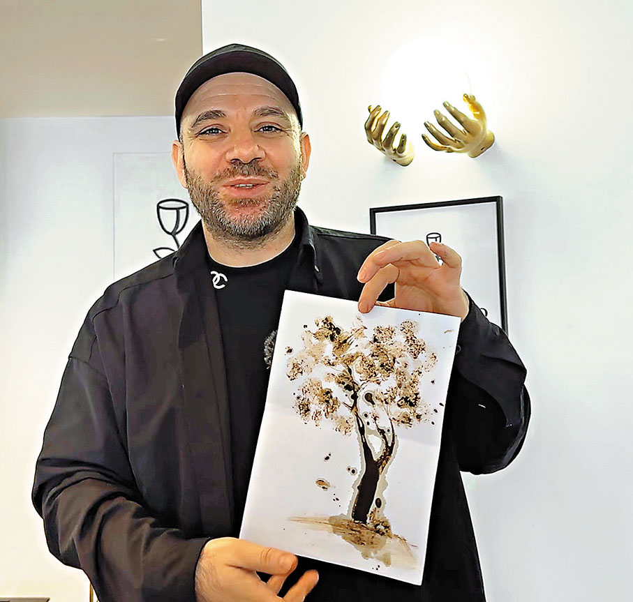 ●林聖開展示用手指蘸咖啡渣創作的作品,表達自己輕鬆的心境。香港文匯報記者于珈琳 攝