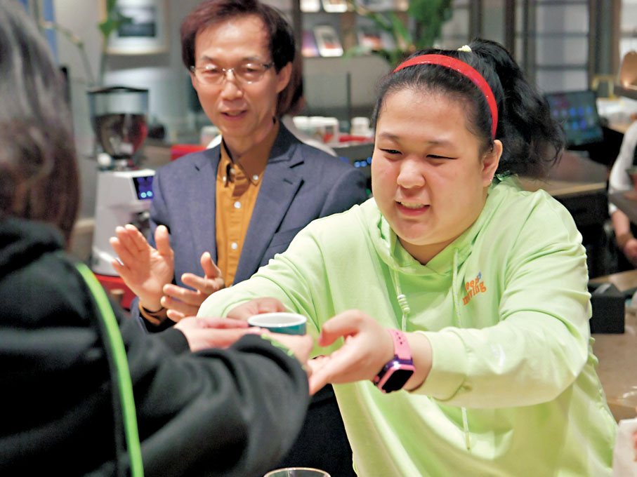 ●長春一家咖啡店內,一位「星星的孩子」(右)將製作好的咖啡遞給顧客。 資料圖片