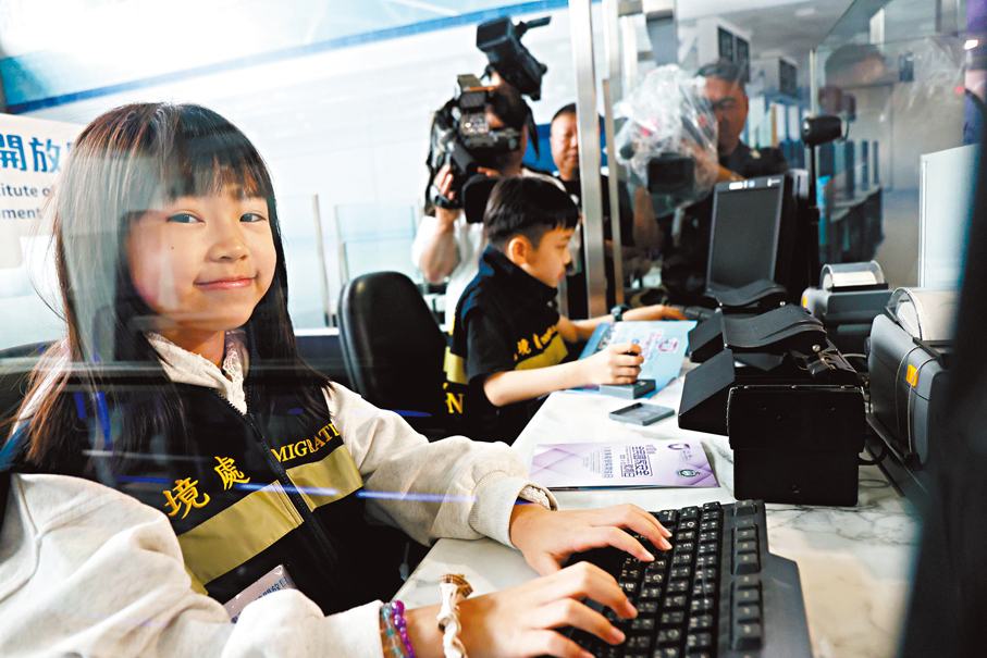 ●吳同學（左）和陳同學在入境檢查櫃「扮工」。香港文匯報記者萬霜靈  攝