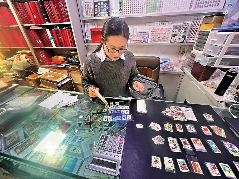 ●郵商白女士向記者展示郵票的真偽鑒定方式。郭瀚林 攝