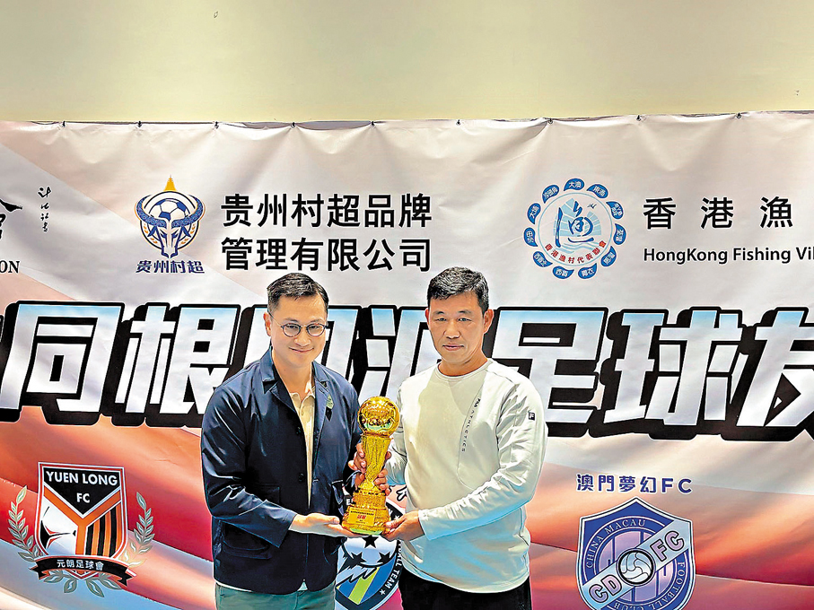 ●台北新世代足球隊代表從中聯辦九龍工作部處長劉湛雄（左）手中接過冠軍獎盃。 香港文匯報記者張發兒  攝