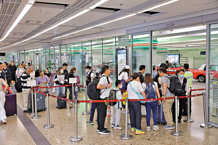 ●市民在西九龍高鐵站的士站取票乘車。香港文匯報記者北山彥  攝