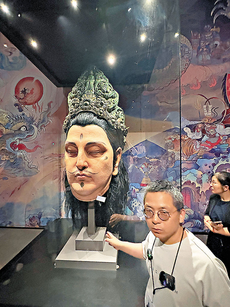 ●策展人宣學君希望遊戲玩家看到展覽場景會有共鳴，他身後正是巨型靈吉菩薩頭像。