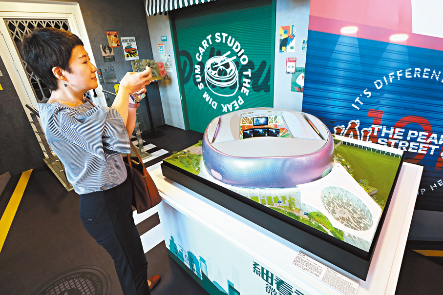 ●《細看香港》微型藝術展參觀者拍攝啟德體育園模型。 香港文匯報記者涂穴 攝