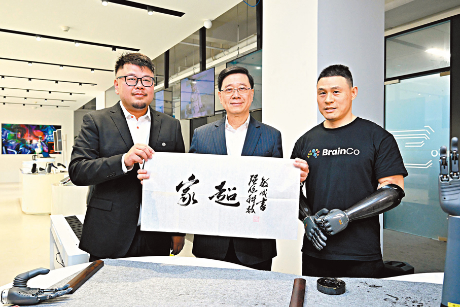 ●李家超早前率團訪問浙江,並邀請「杭州六小龍」來港發展。圖為李家超(中)早前參訪「杭州六小龍」之一的浙江強腦科技有限公司。 資料圖片