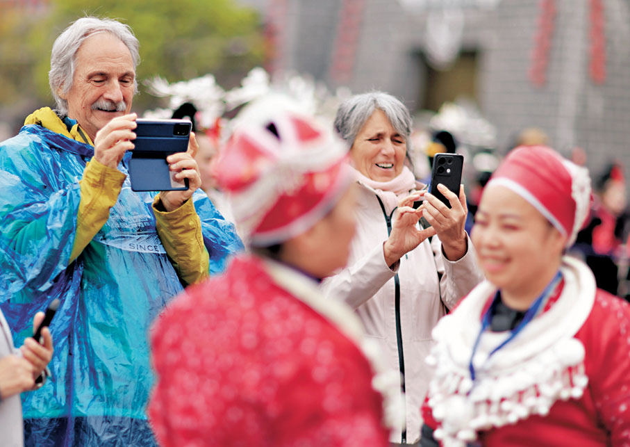 ●4月12日,外國遊客在貴州省黔東南苗族侗族自治州台江縣的「苗族姊妹節」慶祝活動上體驗中國民族風俗。 新華社