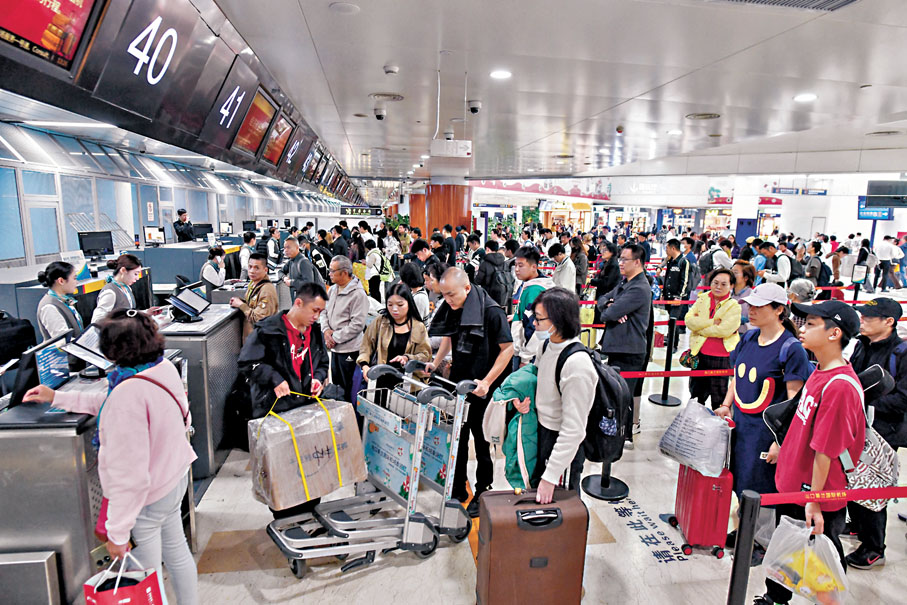 ●今年「五一」假期預計民航旅客運輸量約為1,075萬人次。圖為早前,旅客在海口美蘭國際機場排隊辦理值機。 資料圖片